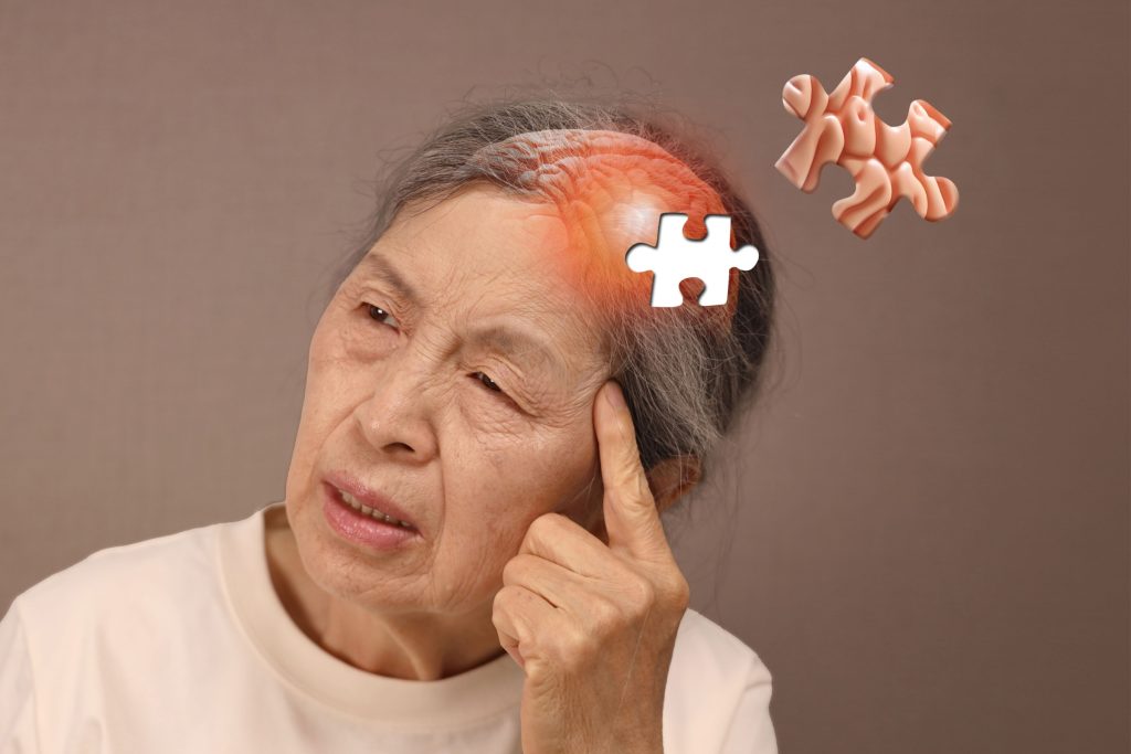 Elderly woman resting her head on her hands trying to recall memories she can't remember. Alzheimer's concept