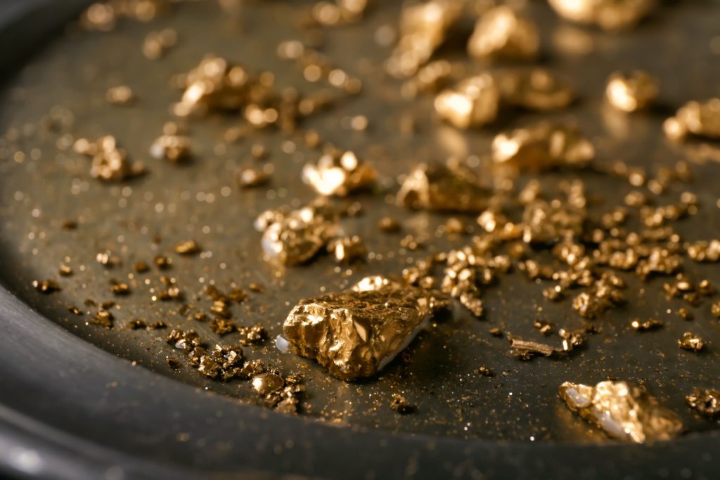 Gold nuggets on metal plate, closeup.