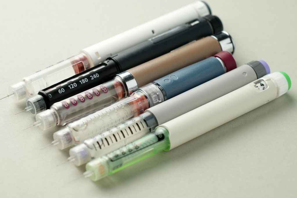 Close-up of multiple injection pens with needles. Concept of semaglutide, GLP-1 drugs, insulin therapy, obesity treatment, diabetes care, pharmaceutical market and weight loss medication.