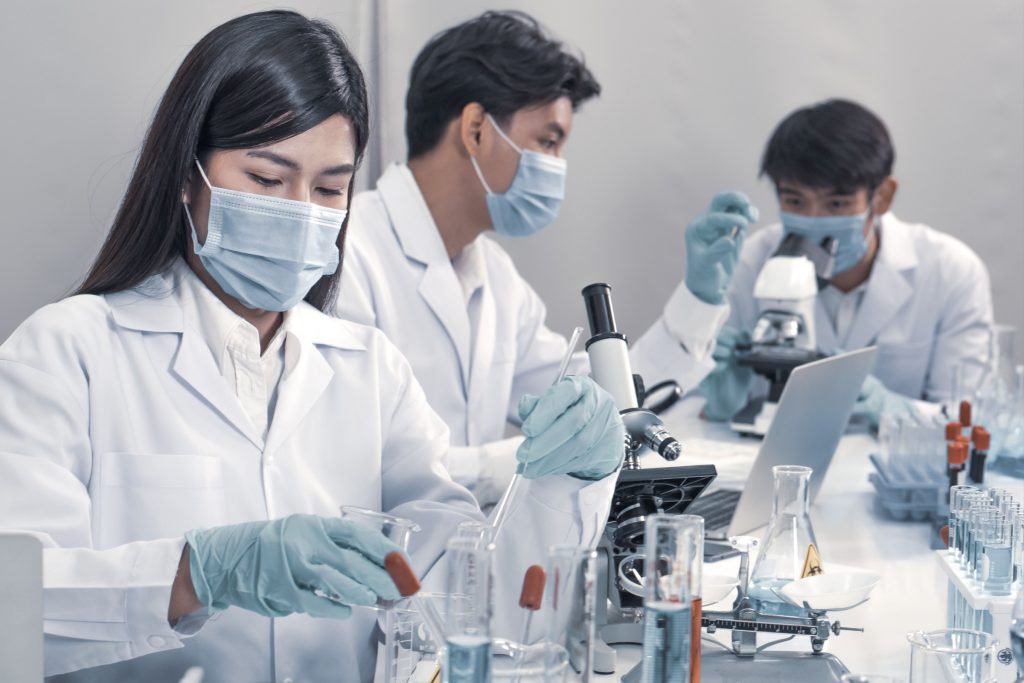 Asian scientists work in hospital pharmacology science research lab. Woman medical scientist and researchers teamwork analyzing innovative virus protective vaccines in health care biology laboratory